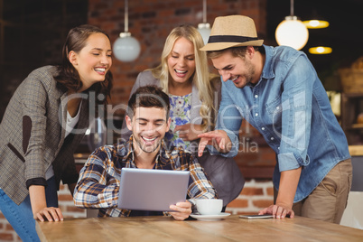 Laughing friends looking at tablet computer