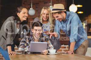 Laughing friends looking at tablet computer