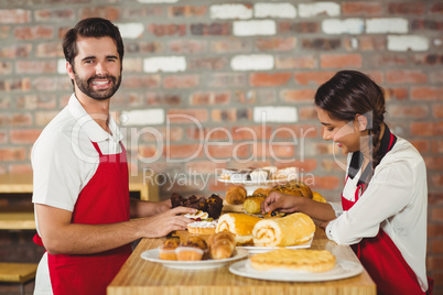 Waiters tidying up pastries on the counter