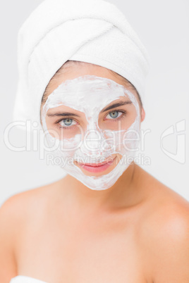 Attractive woman having white cream on her face at spa center