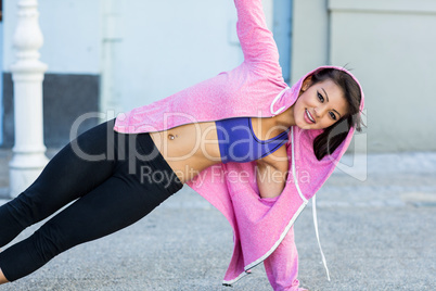 Portrait of athletic woman exercising side plank