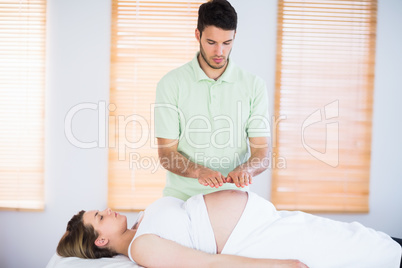 Relaxed pregnant woman getting reiki treatment