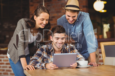 Smiling friends looking at tablet computer Smiling friends looking at tablet computer