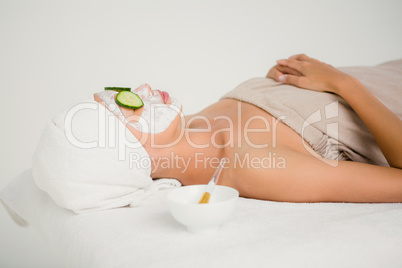 Relaxed woman with cucumber on a creamed face