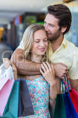 Smiling man kissing his girlfriend on forehead