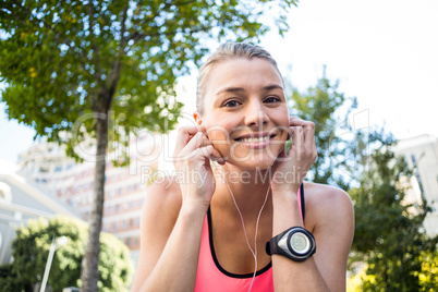 A beautiful athlete putting her headphones