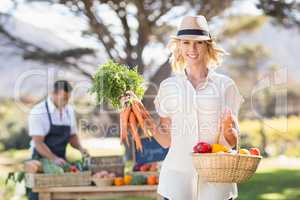 Blonde woman holding a bunch of carrots