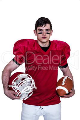 American football player holding helmet and a ball