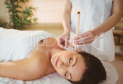 Young woman getting an ear candling treatment