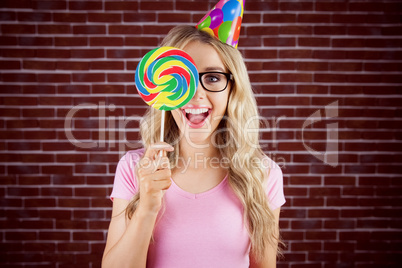 Portrait of a hipster hiding herself behind a lollipop