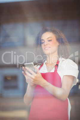 Smiling waitress sending a text