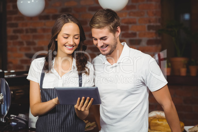 Smiling co-workers using a tablet