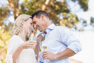 Smiling couple holding wine and looking intensively at each othe