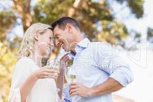 Smiling couple holding wine and looking intensively at each othe