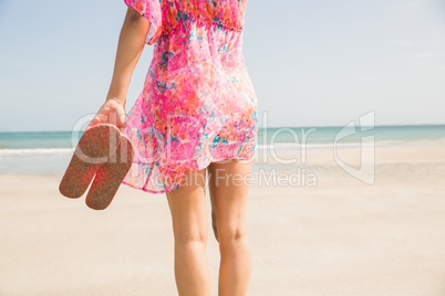 Stylish woman standing on the sand