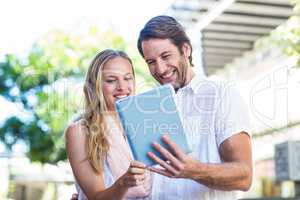 Smiling couple using tablet computer