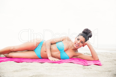 Slim woman sunbathing on towel