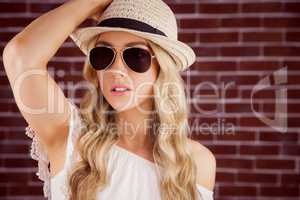 Gorgeous blonde hipster posing with straw hat