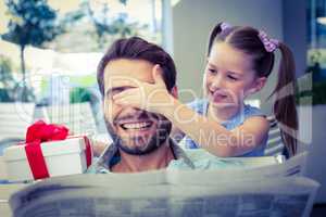 Daughter offering her present to her dad