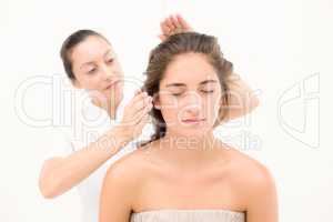 Beautician touching hair of a young woman