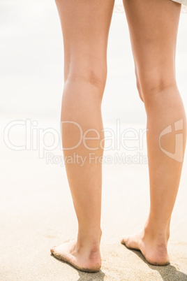 Womans legs standing on the sand