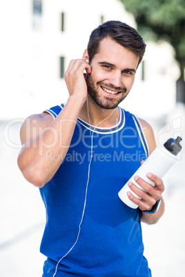 Portrait of an handsome athlete holding a bottle