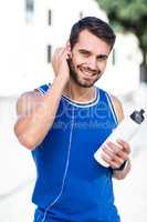 Portrait of an handsome athlete holding a bottle