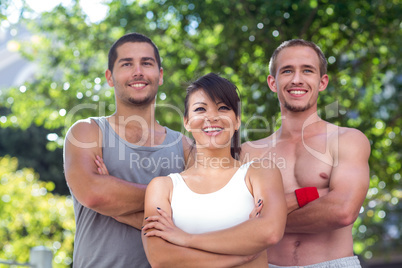 Smiling extreme athletes standing with arms crossed