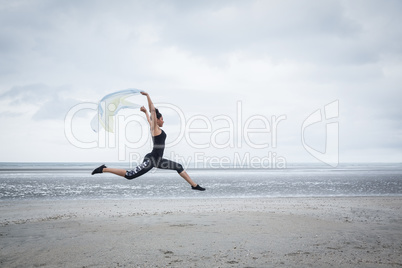 Fit girl leaping with scarf