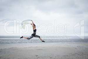 Fit girl leaping with scarf