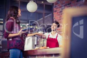 Smiling waiter serving a client