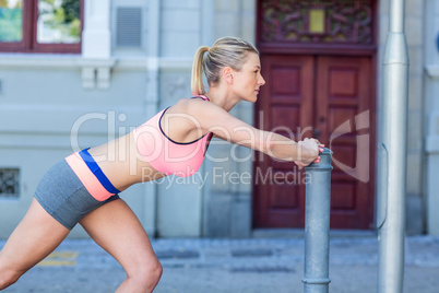 Pretty woman stretching herself on pipe