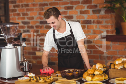 Smiling barista cleaning the counter