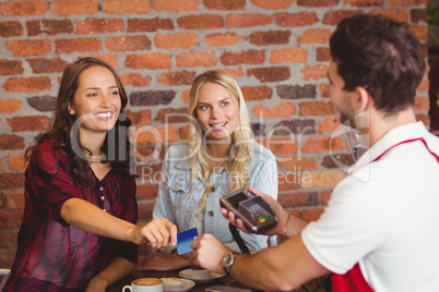 Pretty friends handing a credit card