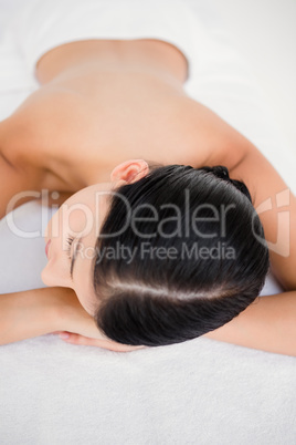 Pretty brunette enjoying a massage smiling at camera