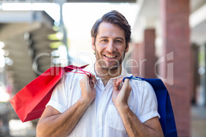 A happy smiling man with shopping bags