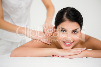 Pretty brunette enjoying a massage smiling at camera Pretty brunette enjoying a massage smiling at camera