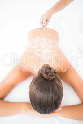 Beautiful brunette enjoying a salt scrub treatment