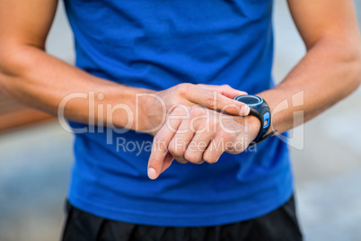 An handsome athlete looking at his watch