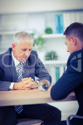 Two businessmen watching crystal ball