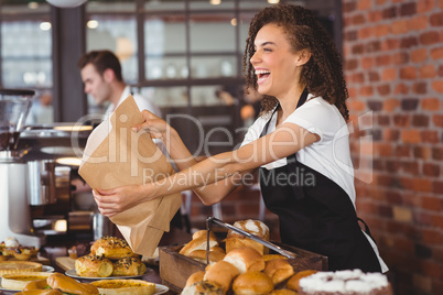 Smiling waitress giving paper bag to customer