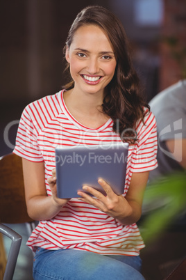 Smiling young woman using tablet computer