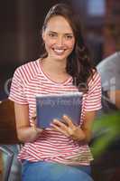 Smiling young woman using tablet computer