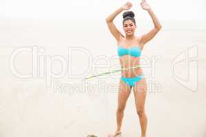 Fit woman hula hooping in bikini