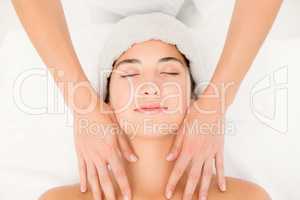 Attractive young woman receiving massage at spa center