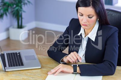 Businesswoman using her smartwatch at desk