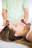 Close up view of relaxed pregnant woman getting reiki treatment