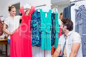 Smiling woman showing red dress to boyfriend