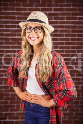 Gorgeous smiling blonde hipster with hands on hips