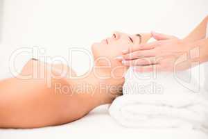 Attractive woman receiving facial massage at spa center